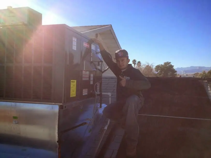 HVAC technician performing HVAC Inspection on a rooftop unit in McCalla